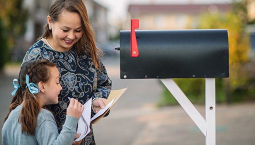 white mother and child checking mail at the mailbox