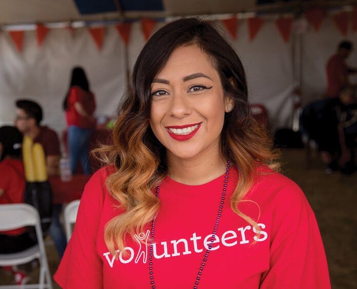 ethnic female volunteer with long hair wearing bright red tshirt