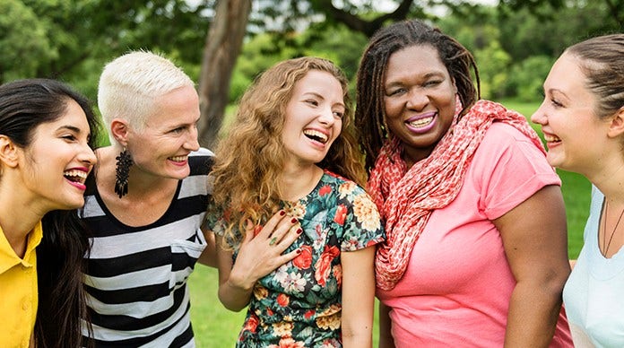 diverse group of women laugh together outside