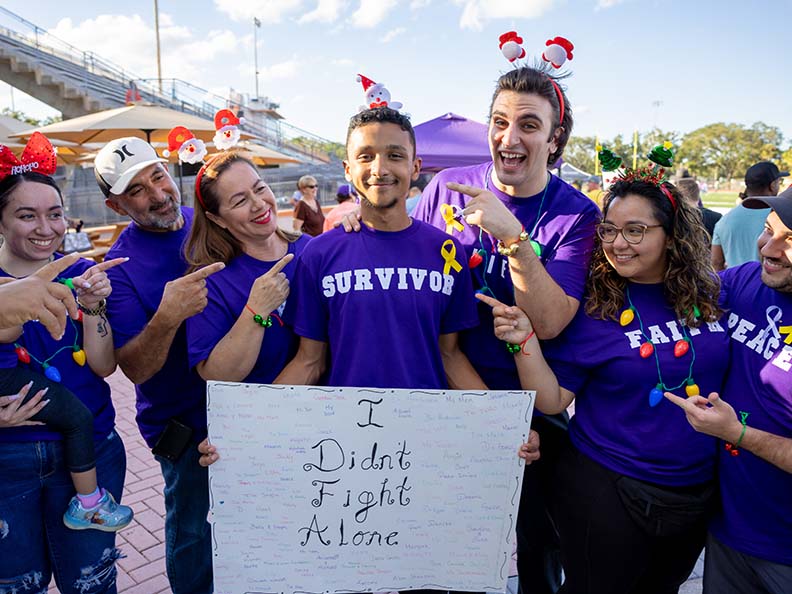 group of people wearing purple shirts at a relay for life event