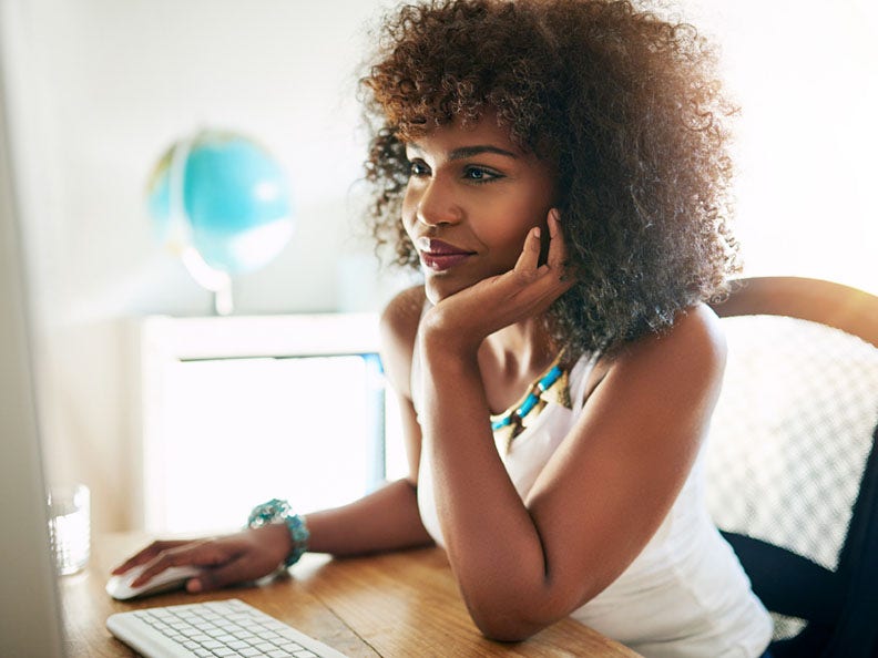 black woman sitting at desk looking at computer